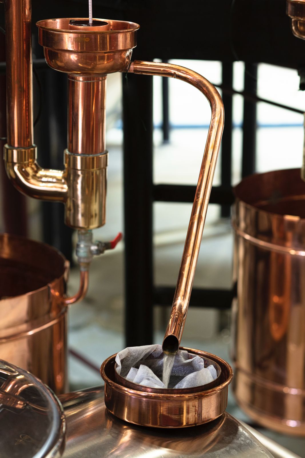 Copper vodka apparatus with a filter and liquid being poured.